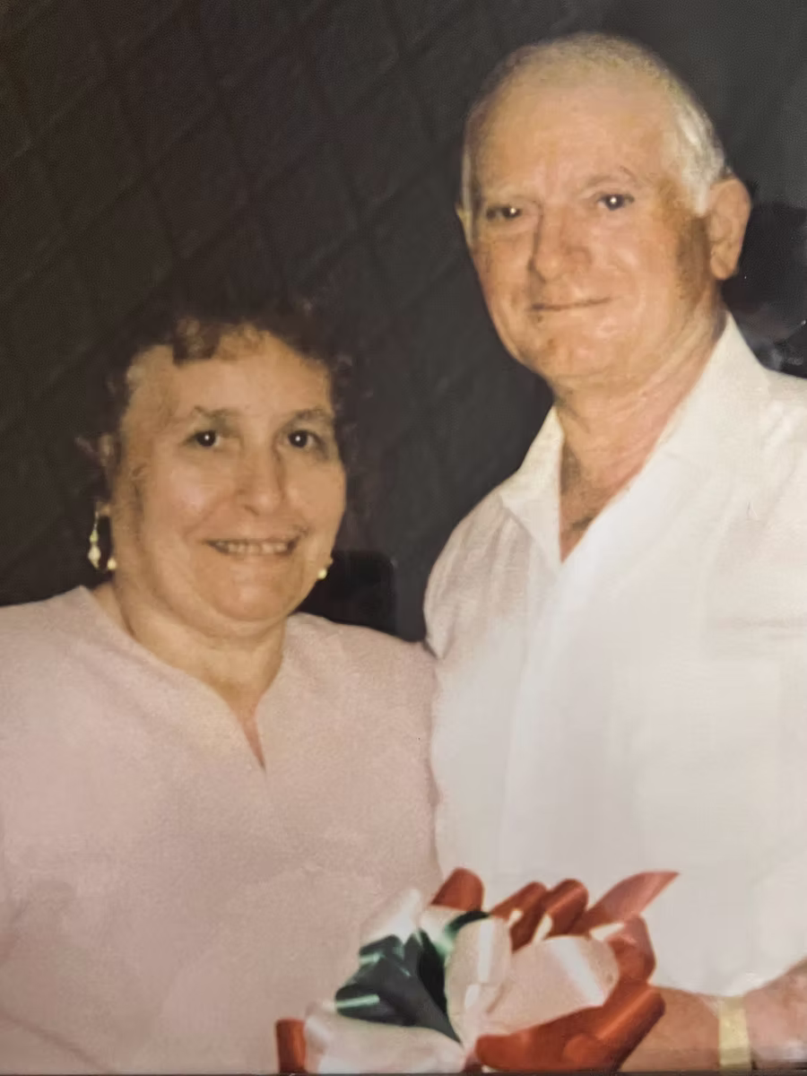 Saverio and Maria Sergi, founders of Sergi's Italian Restaurant, holding Italian flag ribbons
